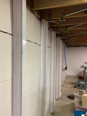 picture of a customer review of Gorilla Wall Braces - a painted white block basement wall straightened with Gorilla Wall Braces